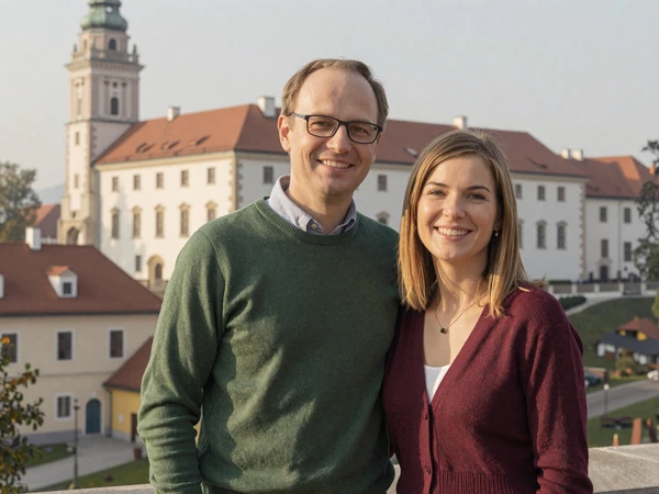 Chris and Maja, an American-Slovenian couple, standing together near Ljubljana Castle on a misty morning